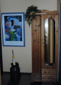 un miroir assis à côté d'une armoire en bois dans l'établissement Ferienwohnung Mit Terrasse In Ruhiger Lage, à Wilhelmshaven