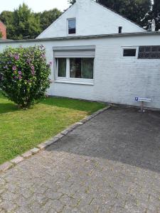 une maison avec un panneau en face d'une allée dans l'établissement Ferienwohnung Mit Terrasse In Ruhiger Lage, à Wilhelmshaven