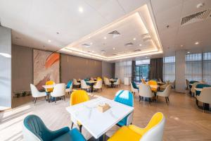 a dining room with tables and chairs at Vienna Hotel Fuzhou Mawei Banzheng Cultural Scenic Area Branch in Fuzhou