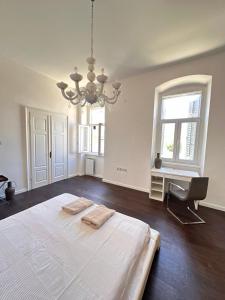a large white bedroom with a bed and a chandelier at Flanatika Residence Pula in Pula +33 photos