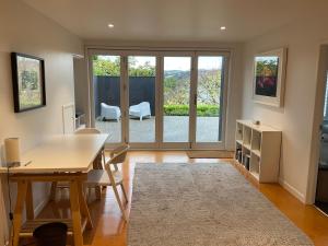 a living room with a table and chairs and a large window at Central City Haven in Auckland +11 photos