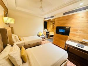 a hotel room with two beds and a flat screen tv at maryland group hotel in Jāmb
