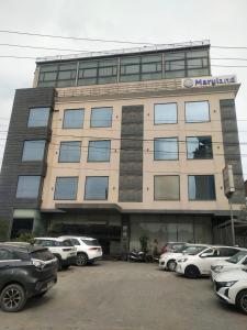 a building with cars parked in front of it at maryland group hotel in Jāmb