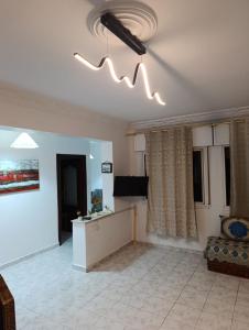 Una sala de estar con un sofá y una lámpara de araña. en appartement marina bay, en Tánger