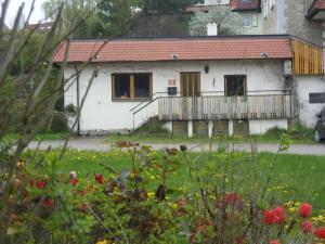 a house with a balcony and a yard with flowers at Ferienwohnung Mit Terrasse Und Parkplatz in Igersheim