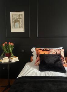 a black bedroom with a bed and a table with books at The Perfect Corner in Pordenone