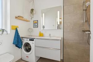 a bathroom with a washing machine and a sink at Feriehus 1135 in Ringkøbing +5 photos