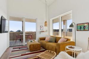 a living room with a couch and a balcony at Feriehus 1135 in Ringkøbing