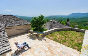 a man sitting in a chair on a patio at Starry Land in Vitsa +6 photos