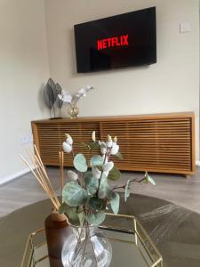 a vase with a plant sitting on a glass table at The Dooley 3-Beds Sleeps 6 Pet Friendly in Liverpool