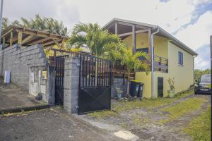 a house with a gate in front of it at Baril Sucré - Piscine- Jardin - By Sister Home in Saint-Philippe