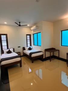 a room with two beds and a table and water at Hotel Grand Palais in Bangalore +47 photos
