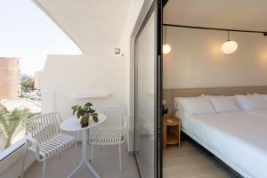 a bedroom with a bed and a table and chairs at Hotel RH Arena - Todo Incluido in Gandía
