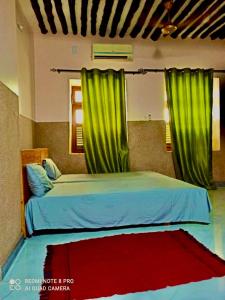 a bedroom with a bed with green curtains at Stone House & Apartment 3 in Zanzibar City