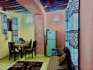 a dining room with a table and a refrigerator at Stone House & Apartment 3 in Zanzibar City