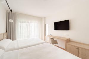 a hotel room with a bed and a desk and a tv at Hotel RH Arena - Todo Incluido in Gandía