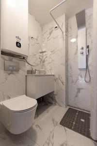 Un baño blanco con inodoro y ducha. en Bohemian Nuance - 15 min from Orly - Calme & Elégance, en Antony