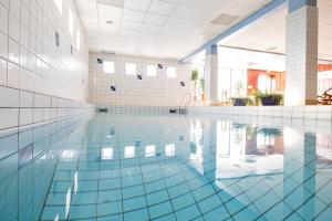 an empty swimming pool with blue tile walls and a large window at Bruksvallslidens förmedling in Bruksvallarna