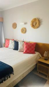 una camera da letto con un letto con cuscini rossi e blu di Clube Praia Mar Portimão - Apartamento a 200 mts da Praia a Portimão