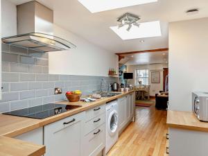 a kitchen with white cabinets and a washer and dryer at 2 bed property in Appledore Devon COCKL in Appledore
