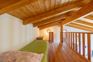 a bedroom with wooden ceilings and a green bed at La Casa Nel Vigneto in Marina San Vito