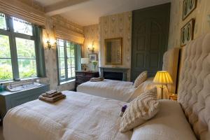 a bedroom with two beds and a bath tub at Belvoir Lodge - Sleeps 18 - Belvoir Castle in Redmile