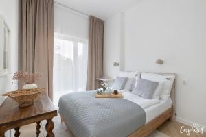 a white bedroom with a bed and a window at Apartament Hygge - z basenem - Easy-Rent Apartments in Pobierowo +38 photos