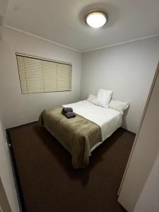 a bedroom with a bed with a pillow and a window at Lakeside 2 Bedroom apartment in Tyger Valley