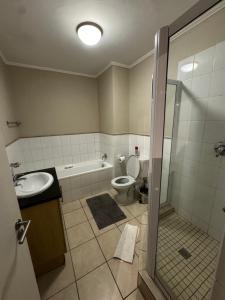 a bathroom with a toilet and a sink and a shower at Lakeside 2 Bedroom apartment in Tyger Valley +6 photos