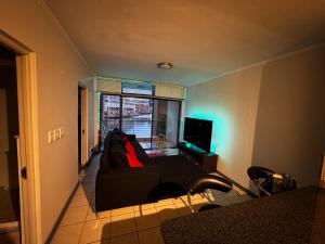 a living room with a couch and a television at Lakeside 2 Bedroom apartment in Tyger Valley