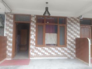un edificio con puertas de cristal y una pared de ladrillo en Habitat Cottages, en Bashist
