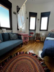a living room with a couch and a bed and windows at Central Artsy Studio, self check-in! in Bucharest