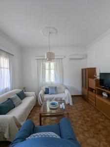 a living room with two couches and a tv at Casa Carmela in Posidhonía