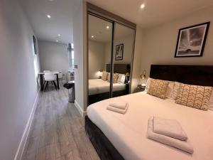 a bedroom with a large white bed with a mirror at Cozy Studio in Bracknell with free Parking in Bracknell