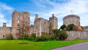 an old castle with a green lawn in front of it at Cozy Studio in Bracknell with free Parking in Bracknell