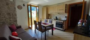 a kitchen with a table and a couch in a room at Appartamento Orobie in Colere