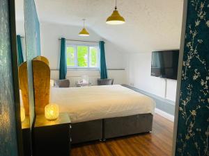 Foots CrayにあるPAVILION ORPINGTON Hotel & Lounge Barの大きなベッドとテレビのある寝室