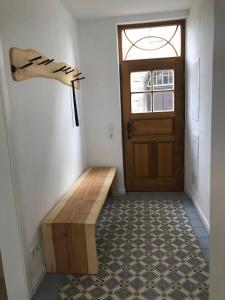 a hallway with a wooden door and a wooden bench at Altstadt Apartment in Pattensen