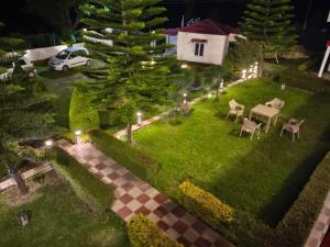 an overhead view of a garden at night with a table and chairs at Mohdev Resort in Jhājra +2 photos