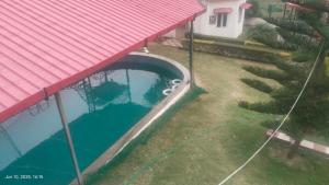 an overhead view of a swimming pool with a red roof at Mohdev Resort in Jhājra