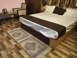 a bed in a bedroom with a rug on the floor at Mohdev Resort in Jhājra