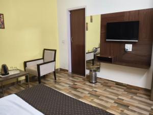 a hotel room with a bed and a flat screen tv at Mohdev Resort in Jhājra