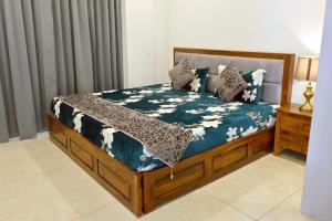 a bed with a blue comforter and pillows at Red Stone Villa - Shimla in Shimla