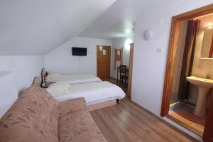 a bedroom with a white bed and a sink at Pensiunea San in Arad