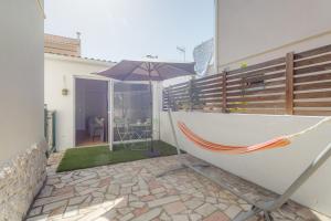 a hammock and an umbrella on a patio at Charming Aroeira Beach Studio in Aroeira