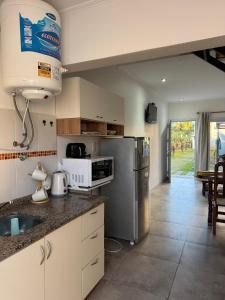 una cocina con fregadero y refrigerador en ByF apart duplex excepcional en complejo Amaiur DPTO N5 Av Alem Norte, en Federación