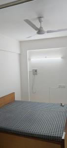 a bed in a room with a ceiling fan at Ews essel tower in Gurgaon