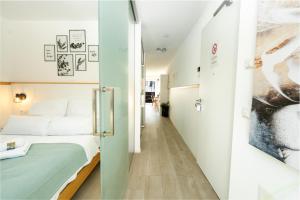 a small room with a bed and a corridor at Sali Homes Apartmenthaus Schlossgasse in Neckarsulm