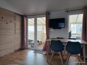 a dining room with a table and chairs and a television at Camping siblu Valras-Plage in Valras-Plage