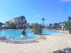 a dolphin fountain in the middle of a swimming pool at Camping siblu Valras-Plage in Valras-Plage